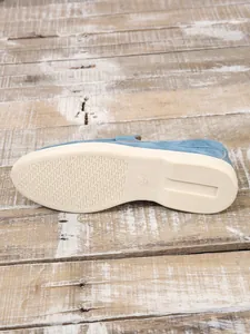 Nahaufnahme der cremefarbenen rutschfesten Sohle eines blauen Wildleder-Loafers