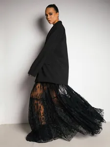 Elegant black high-waisted sheer lace maxi skirt with floral patterns on model