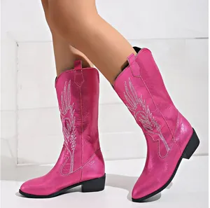 Close-up detail of white feather embroidery on metallic pink metallic cowboy boots
