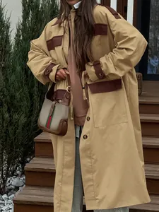 Detail view of a khaki long barn coat with brown accents and classic styling