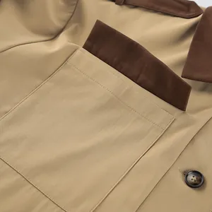 Detailed view of a khaki barn jacket showing pocket stitching and brown fabric accents