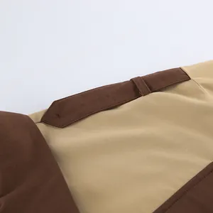 Close-up of khaki and brown contrast fabric detail on long belted overseas coat.