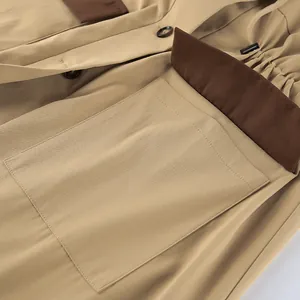 Close-up detail of khaki barn-style coat with large pocket and waist drawstring