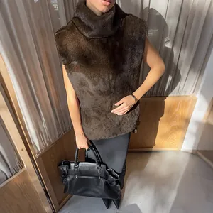 Vista dettagliata di un gilet senza maniche in ecopelliccia marrone con collo alto e borsa