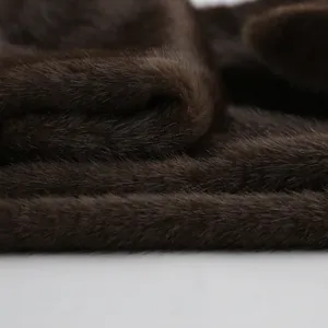 Dettaglio macro della morbida ecopelliccia marrone scuro per gilet invernali caldi.