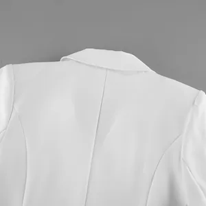 Dettaglio del colletto e delle cuciture delle spalle di un elegante abito blazer bianco.