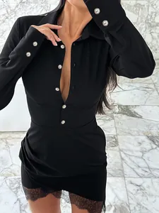 Close-up of black shirt dress featuring pearl buttons and lace patchwork hem