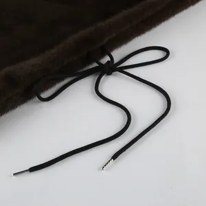 Primo piano del cordoncino nero di un gilet di pelliccia ecologica marrone scuro.