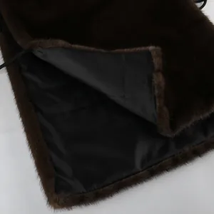 Dettaglio ravvicinato della trama di un gilet in pelliccia sintetica marrone e fodera