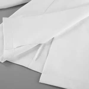 Primo piano dell'orlo di un vestito blazer bianco con cuciture fini e trama del tessuto