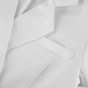 Dettaglio ravvicinato di bavero e tasca di un elegante abito blazer bianco chic