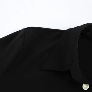 Close-up detail of a black shirt dress collar featuring a decorative pearl button accent