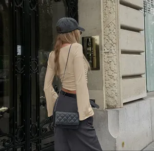 Λεπτομέρεια του κρεμ εφαρμοστού τοπ με καμπάνα μανίκια και κομψές σούρες.
