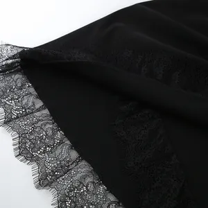 Detailed view of exquisite black lace trim on a slim-fit asymmetrical dress hemline