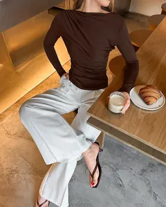 Detailopname van bruine gerimpelde top met lange mouwen en slim-fit design in café