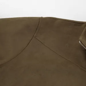 Dichtbij detail van kaki suède jas met hoogwaardige stiksels en metalen ritssluiting