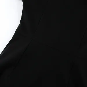 Close-up of waist stitching and fabric texture on a black fitted dress.