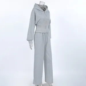 Vista lateral detallada del conjunto de sudadera con capucha gris y pantalón recto.