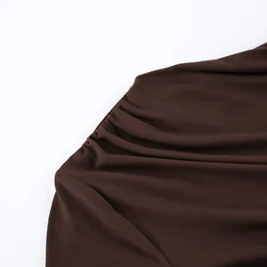 Macrodetail van het gerimpelde ontwerp op dit bruine nauwsluitende shirt met lange mouwen