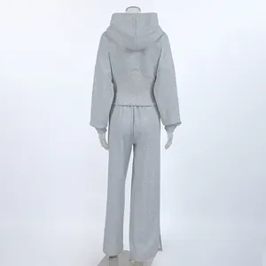 Vista posterior de un conjunto gris jaspeado con sudadera con capucha y pantalón recto.