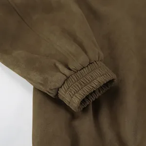 Detail van elastische manchet van kaki suède jasje met een zachte vintage textuur