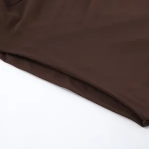 Gedetailleerde weergave van de fijne stiksels en zijzak van de donkerbruine slim fit top