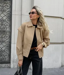 Stilvolle khakifarbene Übergangsjacke im französischen Design an blondem Modell im Freien