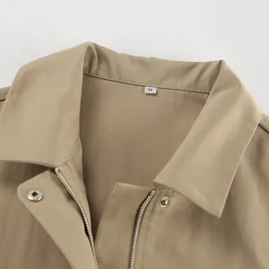 Detailansicht des khakifarbenen Trenchcoats mit französischem Revers und M-Größenetikett.