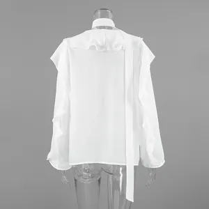 Vista posterior de una blusa blanca suelta con elegantes detalles de volantes y manga larga.
