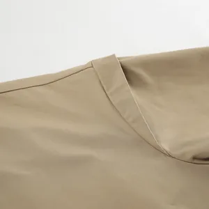 Nahaufnahme von einem minimalistischen khakifarbenen Trenchcoat-Revers mit feiner Stoffstruktur