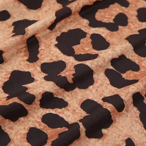 Macro detail of knitted leopard print fabric with soft texture and rich brown tones.