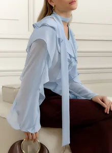 Detalle de la blusa de gasa azul claro con cuello en V y elegantes mangas con volantes