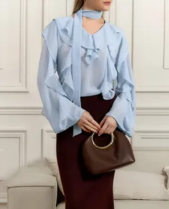 Elegante blusa azul claro con cuello en V, volantes en capas y lazo al cuello