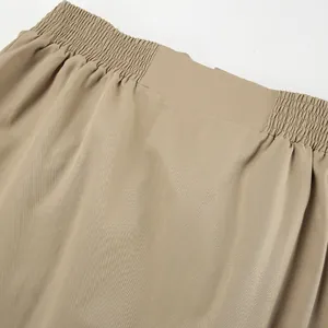 Nahaufnahme des elastischen Bunds und der khakifarbenen Stofftextur eines Trenchcoats