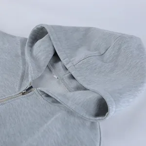 Primer plano detallado de una sudadera gris con capucha y textura de la cremallera