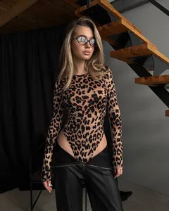 Leopard print long sleeve bodysuit styled with leather trousers in a modern interior.