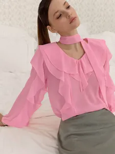 Vista detallada de blusa rosa con volantes, manga larga, elegante cuello en V y gargantilla.