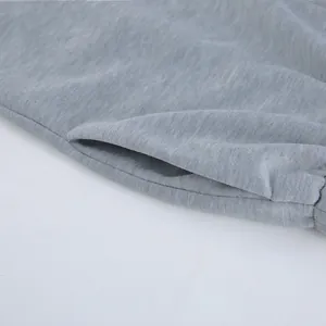 Primer plano que muestra el detalle del bolsillo lateral en un conjunto de punto gris