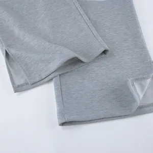 Detalle del dobladillo con abertura y textura acanalada en pantalón de punto gris