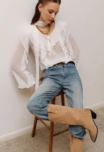 Elegante blusa blanca con cuello en V, mangas con volantes y gasa ligera.