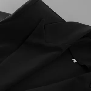 Detailed close-up view of a professional black suit jacket collar and size L tag