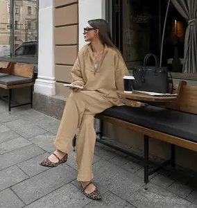 Close-up of khaki oversized half-zip tracksuit set styled in an urban street setting.