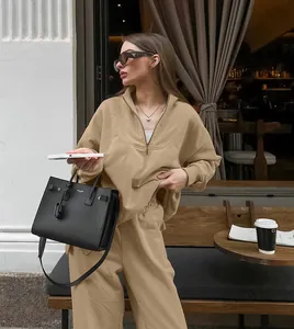 Street style khaki oversized sweatshirt and trousers set worn by model at outdoor cafe