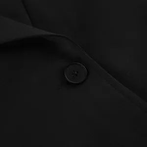 Macro detail of black blazer jacket showing high-quality fabric texture and button