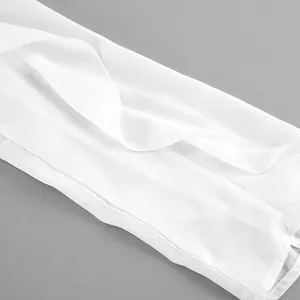 Detalle de la manga con volantes de gasa blanca en una elegante blusa de manga larga