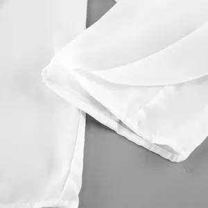 Detalle de primer plano del dobladillo con volantes y la textura de una blusa de gasa blanca