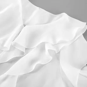 Detalle macro de elegante blusa blanca con cuello en V y volantes de varias capas