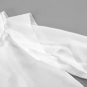 Detalle de blusa blanca con cuello en V, elegantes mangas con volantes y tela suave
