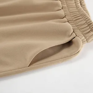 Detailed close-up of khaki jogger waistband and side pocket showing premium fabric texture