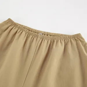 Primo piano dettagliato di pantaloni in cotone e lino kaki con vita elastica flessibile.